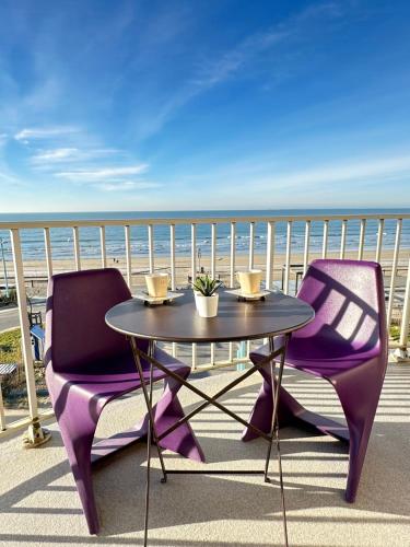 圣让-德蒙T2 La vue panoramique sur l'océan à 180的阳台配有一张桌子和两把椅子,享有海景
