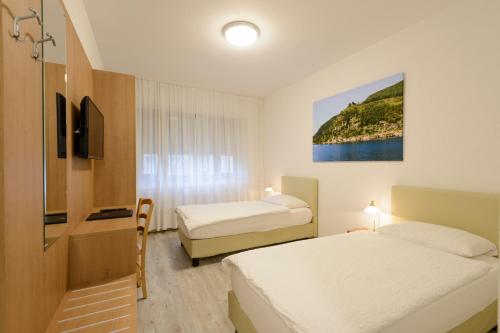 卢加诺切雷西奥酒店的一间酒店客房,设有两张床和电视