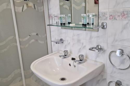 阿博伦Hazeldene的白色的浴室设有水槽和淋浴。