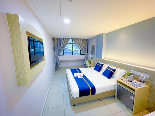 吉隆坡StarQ Hotel Bukit Bintang的酒店客房,配有床和电视