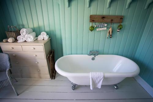拉尔沃思湾拉尔沃思湾酒店的一间带白色浴缸和梳妆台的浴室