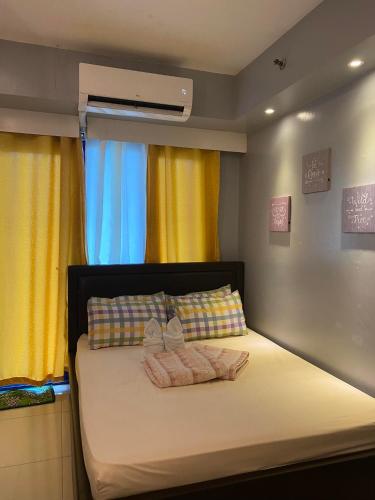 马尼拉Sea Residences的一间卧室配有一张床,上面有两条毛巾