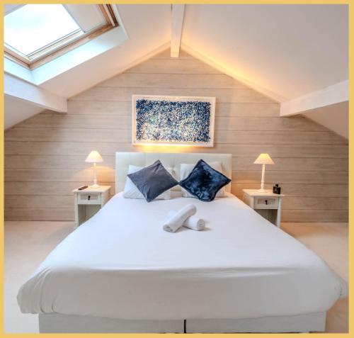 MarcellazVilla T5 Luxury Marcellaz的卧室配有一张带两张桌子的大型白色床