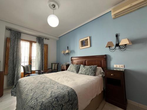 科尔多瓦梅斯特雷酒店的一间卧室设有一张床和蓝色的墙壁
