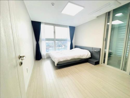 首尔Hoban Apartment, KonKuk Univ Station的一间卧室设有一张床和一个大窗户