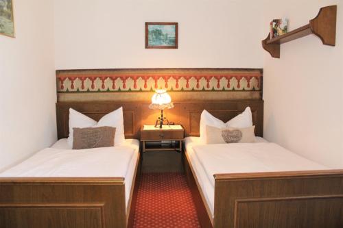 柯尼希斯湖畔舍瑙Schneck Apartments的客房设有两张床和一张带台灯的桌子。