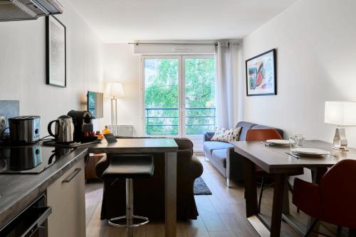 里尔Lille Centre - Superb bright apartment parking的厨房以及带桌子和沙发的客厅。
