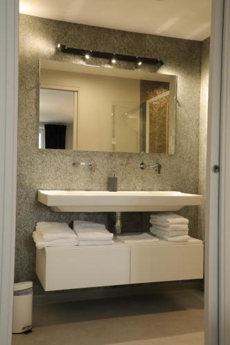 纳斯比纳勒Le Relais de l'Aubrac的一间带水槽和镜子的浴室