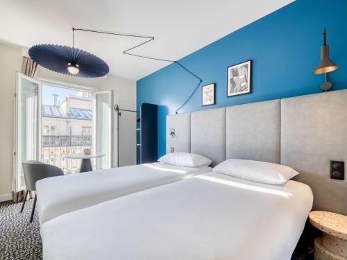 巴黎宜必思巴黎拉雪兹酒店的一张白色的大床,位于一个蓝色的墙壁上