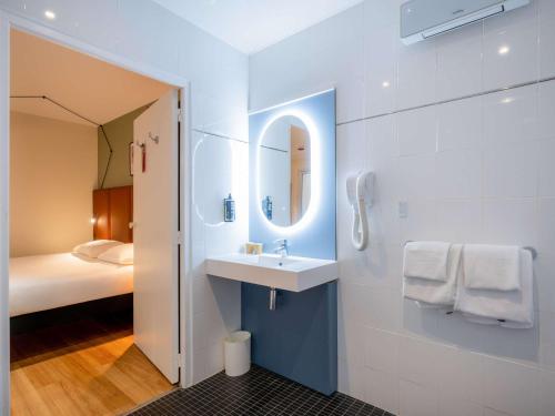 巴黎宜必思巴黎拉雪兹酒店的一间带水槽和镜子的浴室以及一张床