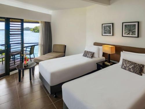 苏瓦诺富特苏瓦拉米湾酒店的酒店客房设有两张床和一个阳台。