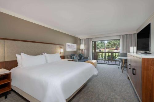 科罗拉多斯普林斯Cheyenne Mountain Resort, a Dolce by Wyndham的酒店客房设有一张白色大床和一台电视。