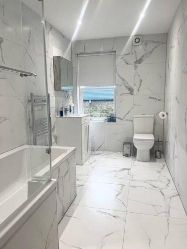 沃辛Luxury 3 Bedroom House的白色的浴室设有卫生间和窗户。
