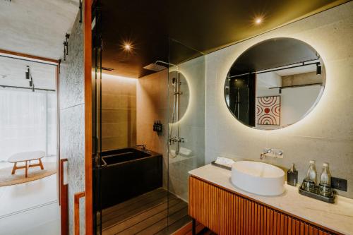 坎古The Komu的一间带水槽、浴缸和镜子的浴室