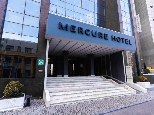 巴库Mercure Baku City的一座位于酒店前方的带楼梯的小型酒店大楼