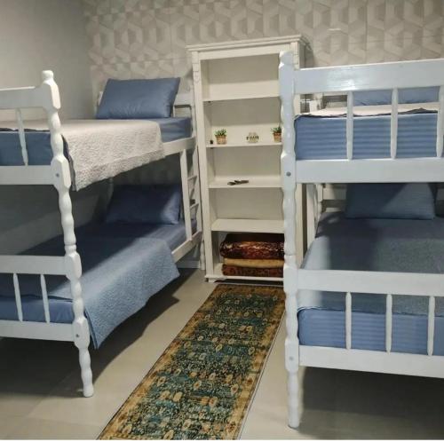 布卢梅瑙Hostel SIL CARDOSO的卧室配有两张双层床和地毯。