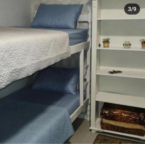 布卢梅瑙Hostel SIL CARDOSO的卧室内的双层床,配有蓝色枕头