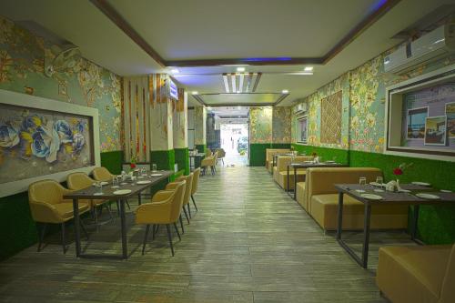 瑞诗凯诗Q Saina S K Regency Rishikesh的用餐室设有桌椅和绿色的墙壁