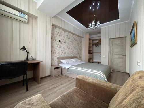 比什凯克AURA on Ryskulov street 30的一间卧室配有一张床、一张桌子和一张沙发