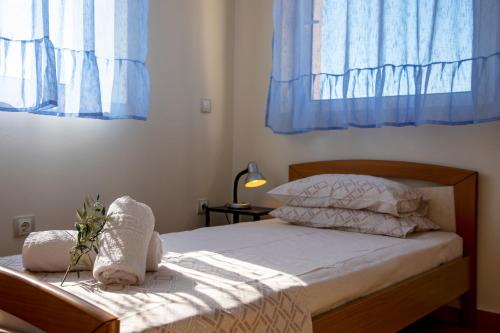 AegenitissaAegina Sea View Villa的一间卧室配有蓝色窗帘的床