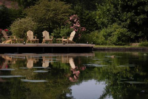 DannesMoulin Moulin Maison d'Hôtes的湖畔码头上坐着三把椅子