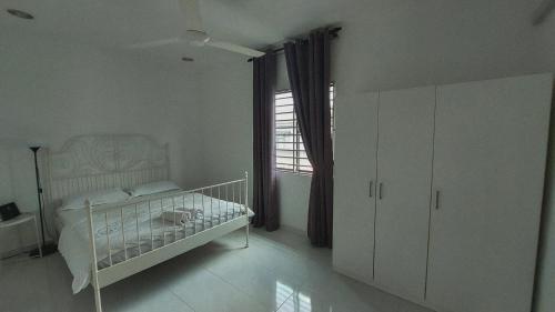 居林D'Sandra Homestay的白色的卧室设有床和窗户