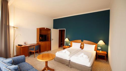 博尔库姆Upstalsboom Borkum的酒店客房,配有床和沙发