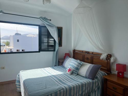 蓬塔穆赫雷斯Romantico con piscina privada solo para ti的一间卧室设有一张床和一个大窗户