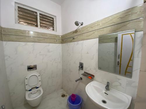 海得拉巴Hotel Plaza Rooms的一间带卫生间、水槽和镜子的浴室