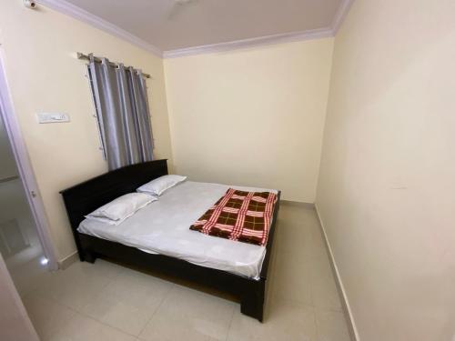 海得拉巴Hotel Plaza Rooms的小卧室配有一张带毯子的床