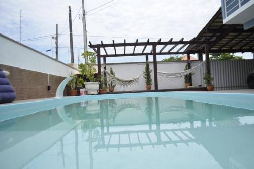纳韦甘蒂斯Casa de Alto Padrão próxima ao Beto Carrero的一座带凉亭的游泳池,位于一座房子旁边
