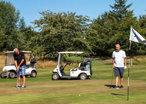 莫珀斯Percy Wood Country Park的两个男子用高尔夫球车打高尔夫