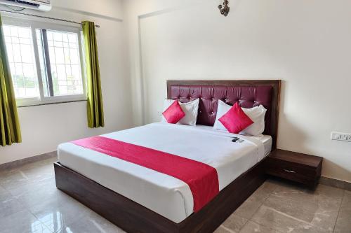 班加罗尔FabHotel KSP Kings Inn的卧室配有一张带粉红色枕头的大床