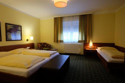 瓦格纳Hotel Restaurant Neuhold的酒店客房设有两张床和窗户。