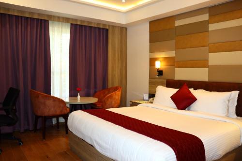 特里凡得琅Capital Park Residency的酒店客房配有一张床铺和一张桌子。