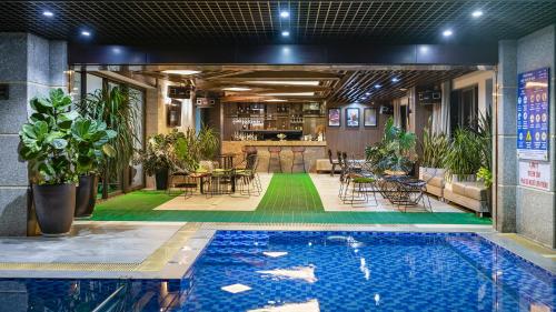 吉婆岛Cat Ba Paradise Hotel- Pool & Sky Bar的一座带酒吧的建筑中央的游泳池