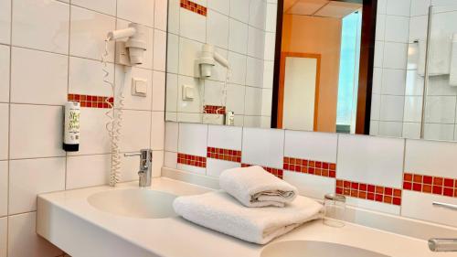 博特罗普博特罗普莱茵鲁尔酒店的一间带水槽和镜子的浴室