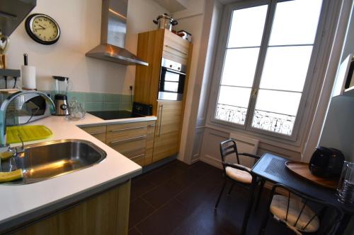 托农莱班Appartement avec vue 180 sur le Lac Léman的厨房配有水槽和桌椅