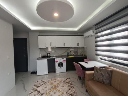 BostancıFatih apart otel的厨房以及带沙发和桌子的客厅。