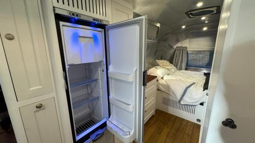 克努斯福德Airstream Experience的配有床的小客房内的开放式冰箱