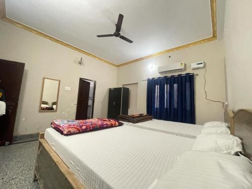 王舍城Hotel moon light的一间卧室配有两张床和吊扇
