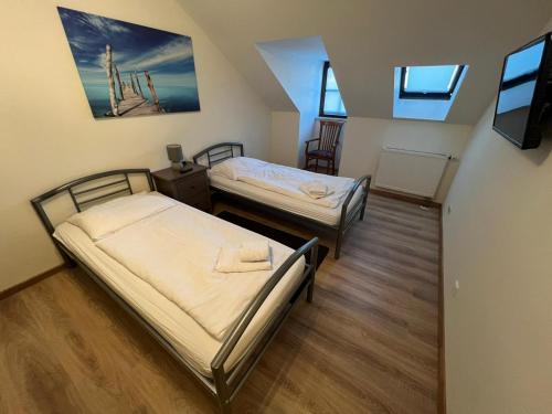 埃朗根舒米特酒店的一间设有两张床和一台电视的房间