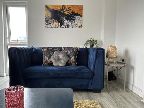 贝尔法斯特Central Belfast Apartments Sandford的客厅配有带枕头的蓝色沙发