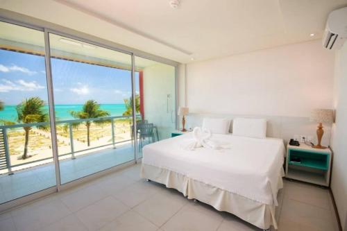 马拉戈日普拉亚多拉达酒店的一间卧室配有一张床,享有海滩美景