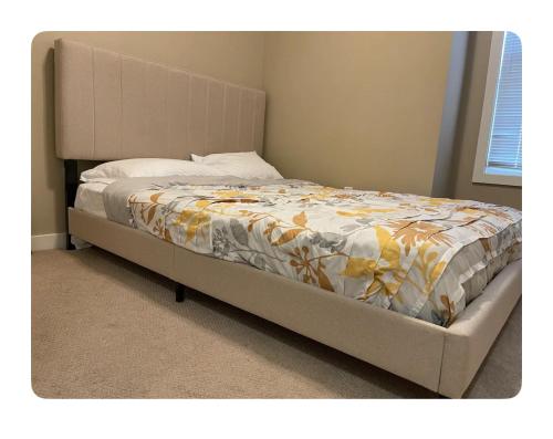 埃德蒙顿Edmonton的床上铺有黄色和白色的棉被