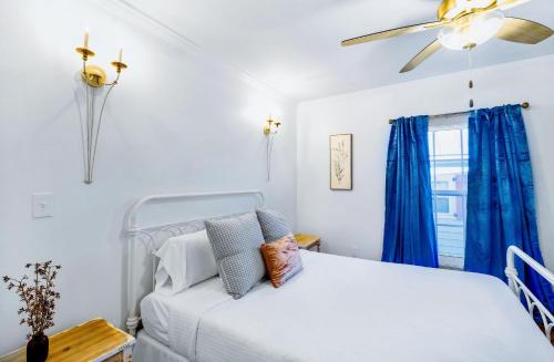 比洛克西Old Spanish House- C, The Madeleine Suite的一间卧室配有白色的床和蓝色窗帘