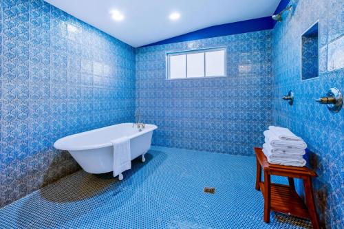 比洛克西Old Spanish House- C, The Madeleine Suite的浴室设有蓝色瓷砖墙壁和浴缸。