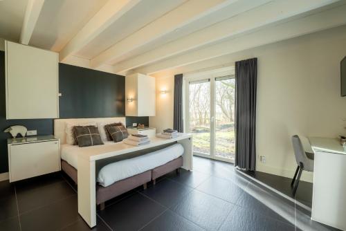 布兰肯贝赫De Rietreiger的一间卧室配有一张带书桌的床和窗户。