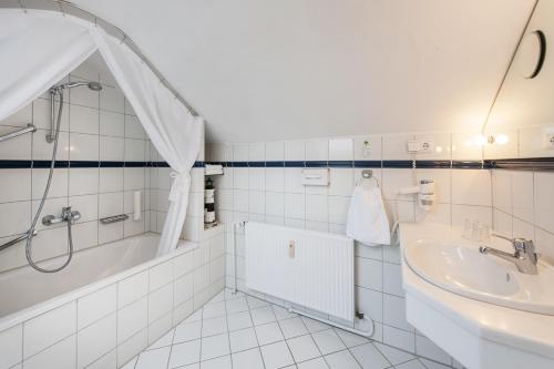 基尔Hotel Birke - Appartments Waldesruh的白色的浴室设有浴缸和水槽。