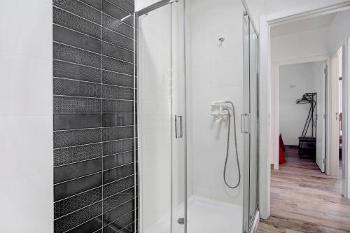 莱里亚Casa da Padaria的浴室铺有黑色瓷砖,设有淋浴。